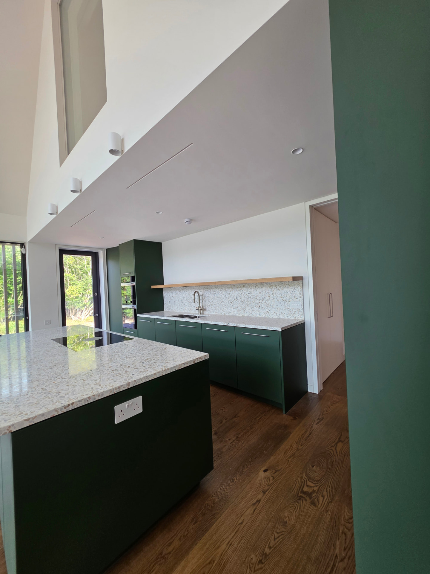 Open-plan kitchen with concealed linear supply vents in the ceiling